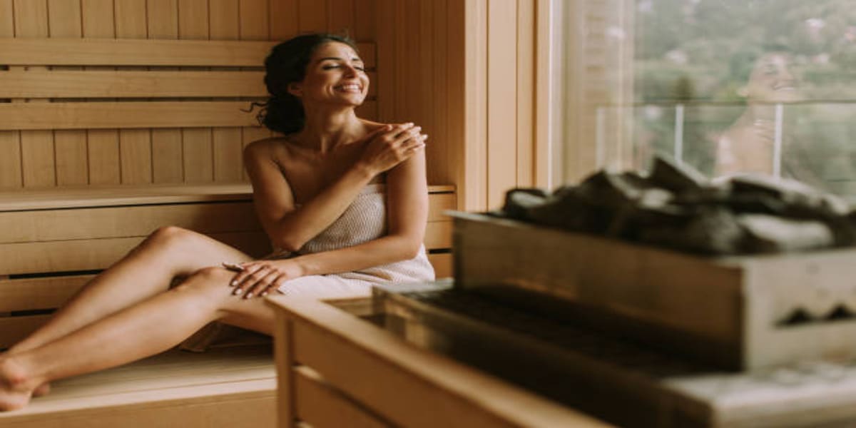 Person relaxing in a traditional Harvia sauna enjoying sauna health benefits